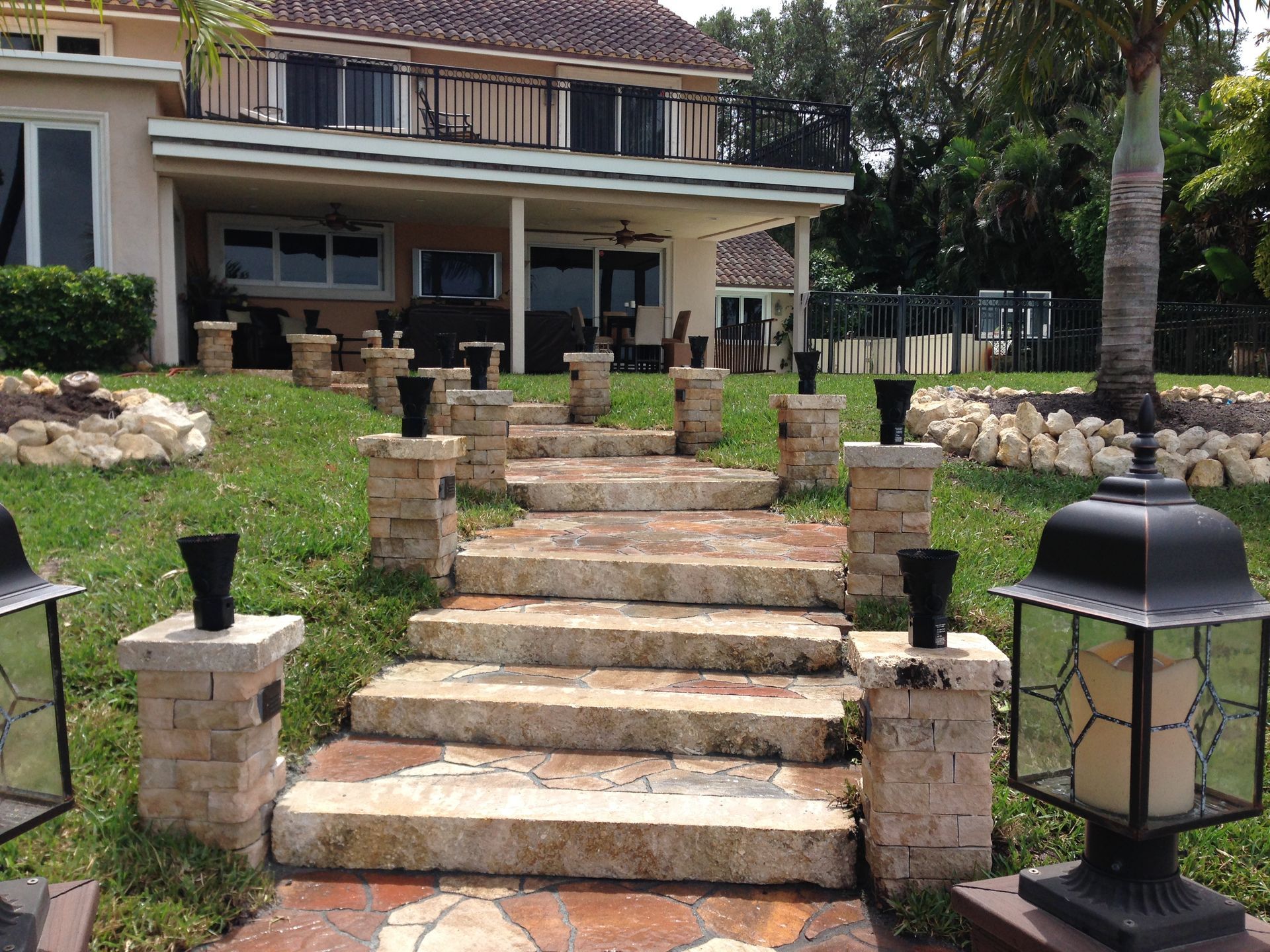 A stone walkway leading up to a large house