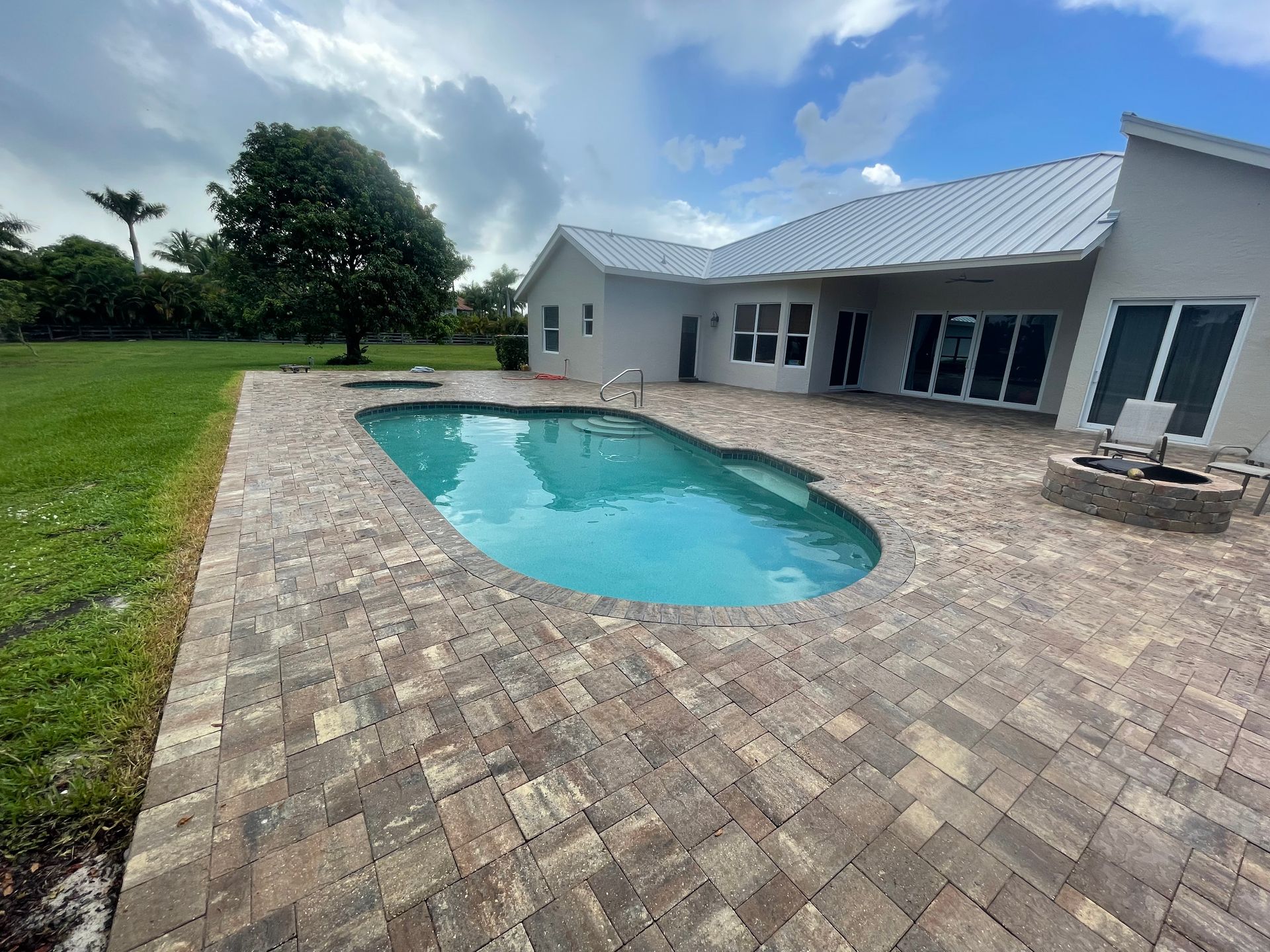 A large swimming pool is in the backyard of a house.