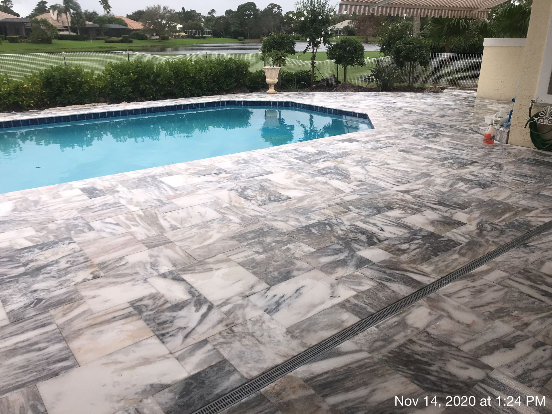 A large swimming pool with a patio in front of it