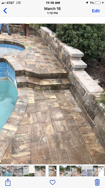 A picture of a patio next to a pool on a cell phone.