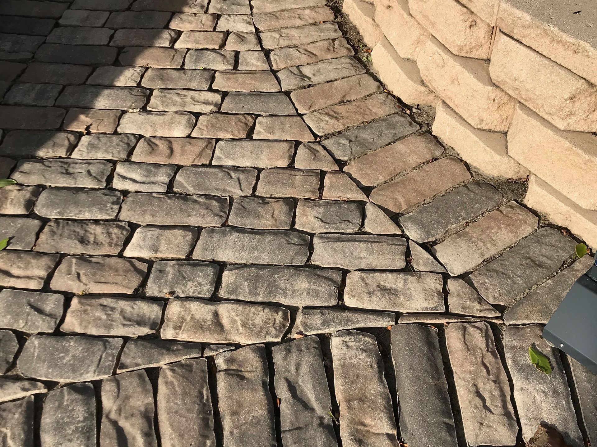 A brick walkway with a stone wall in the background.