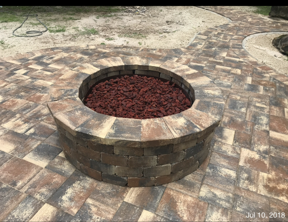 A fire pit is sitting on top of a brick patio.