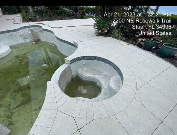 A swimming pool with a hot tub in the middle of it