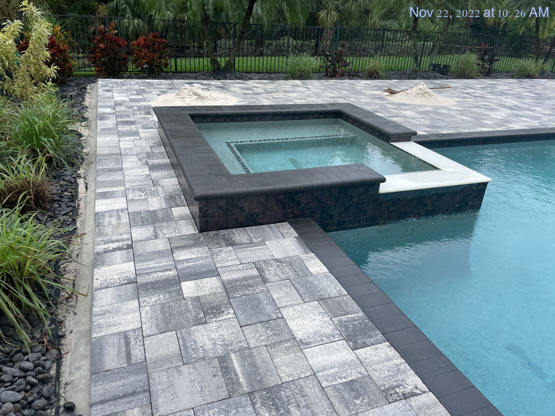 A swimming pool with a hot tub in the middle of it