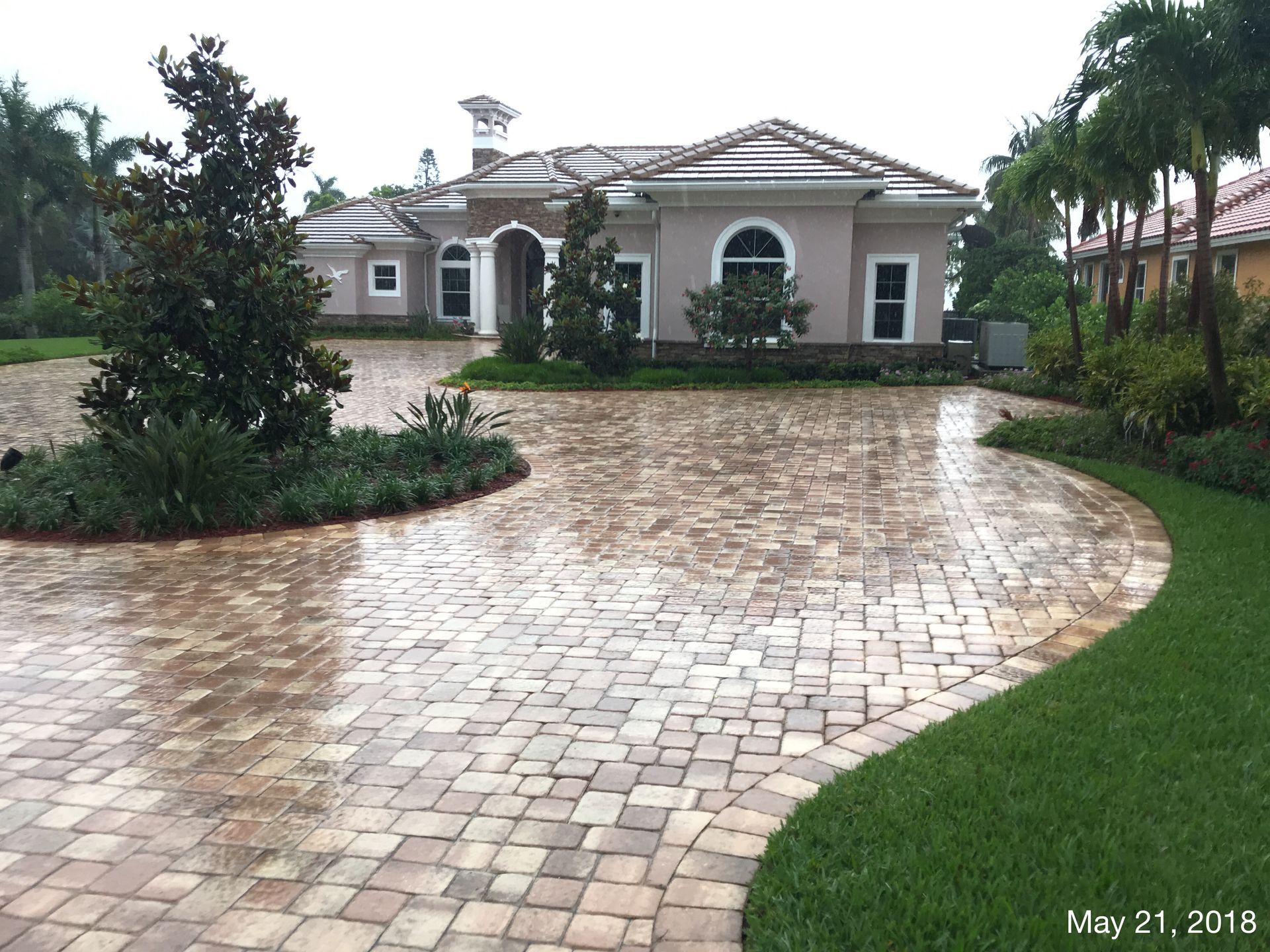 A brick driveway leading to a large house on may 21, 2018