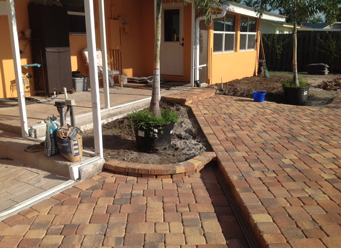 A brick walkway in front of an orange house