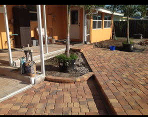 A brick walkway is being built in front of a house