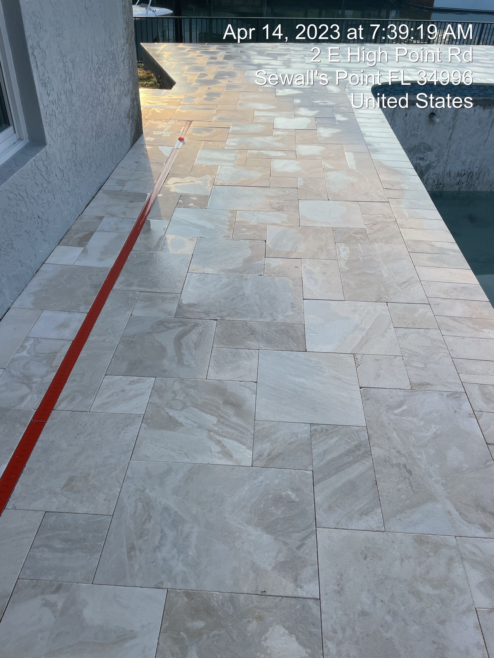 A tiled walkway with a red line on it