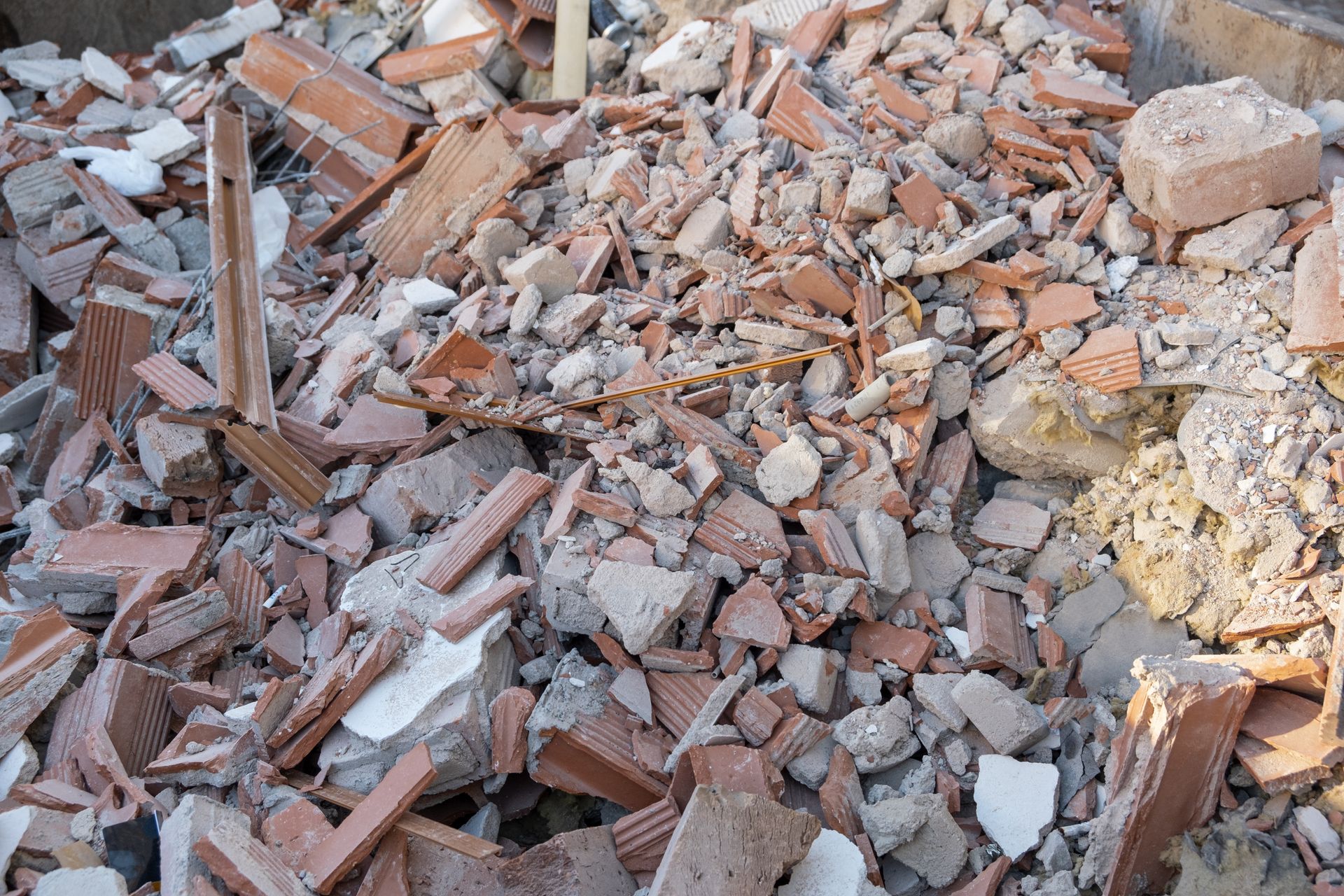 Pile of broken bricks, rubble, and construction debris scattered on the ground.