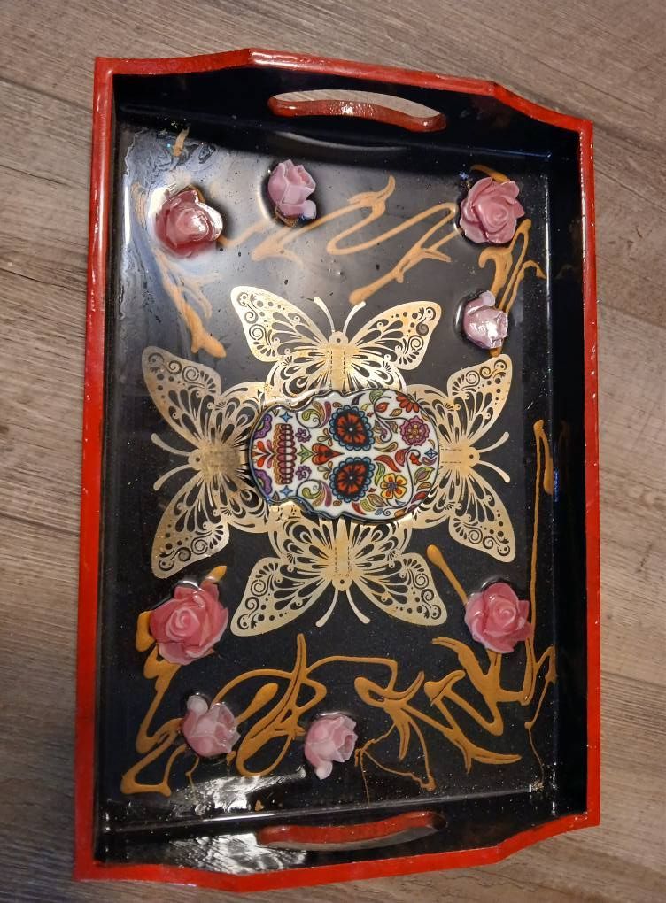 Black tray with gold butterfly design, red border, pink roses, and a decorative center piece.