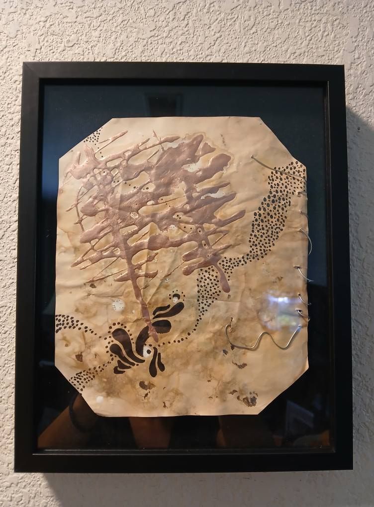 Framed artwork: brown and black ink on aged paper, abstract tree, dotted lines, and decorative bird-like shape.