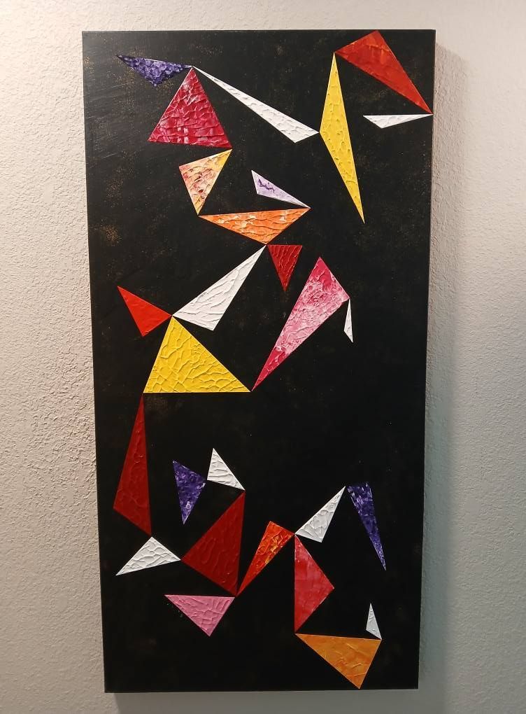Abstract painting of colorful triangles on a black background.