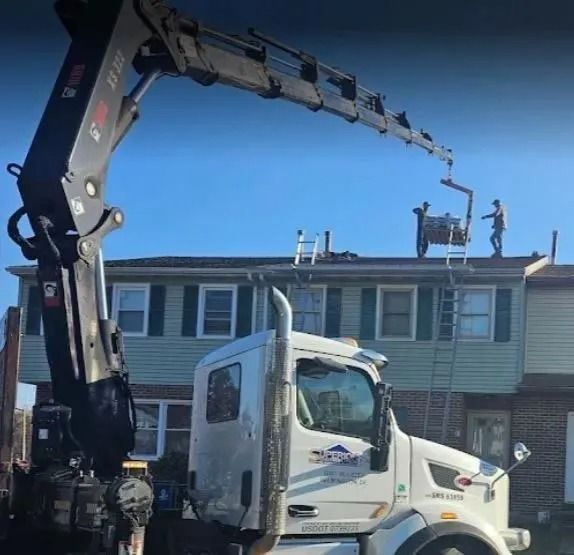 Roofer installing dark asphalt shingles on a roof.