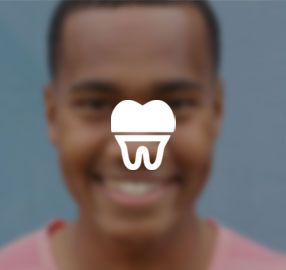 A man is smiling with a tooth icon in front of his face.