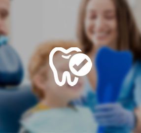 A tooth with a check mark on it is being examined by a dentist.