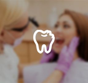 A woman is getting her teeth examined by a dentist.