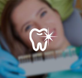 A woman is getting her teeth whitened by a dentist.