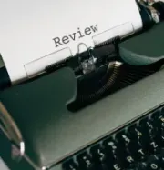 Typewriter with paper reading “Review” in a dark close-up view