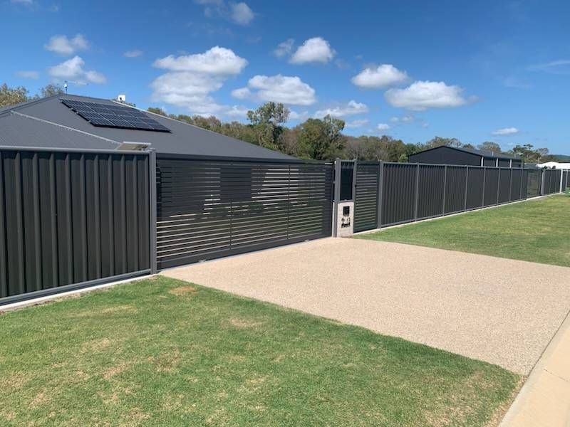Gray House With Matching Fence, Solar Panels, and Gravel Driveway — The Fence Place in Kawana, QLD