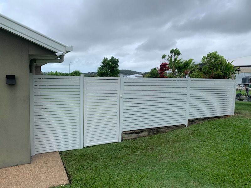 White Slatted Fence and Gate Beside a House on a Cloudy Day — The Fence Place in Kawana, QLD