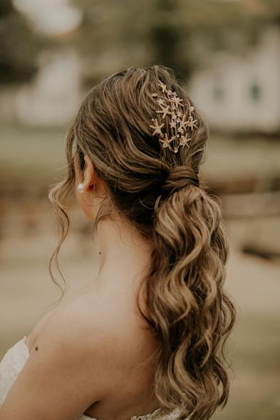 The back of a bride wearing a ponytail with stars in her hair.