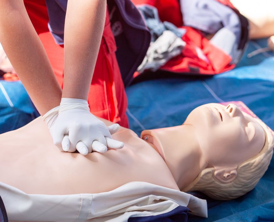 A person is giving a heart massage to a mannequin.
