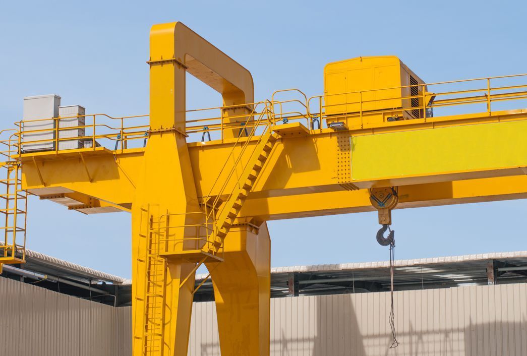 A large yellow crane is sitting in front of a building.