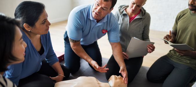 A group of people learning CPR using a mannequin.