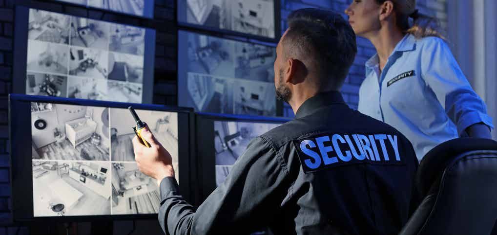 A man and a woman are looking at monitors in a security room.