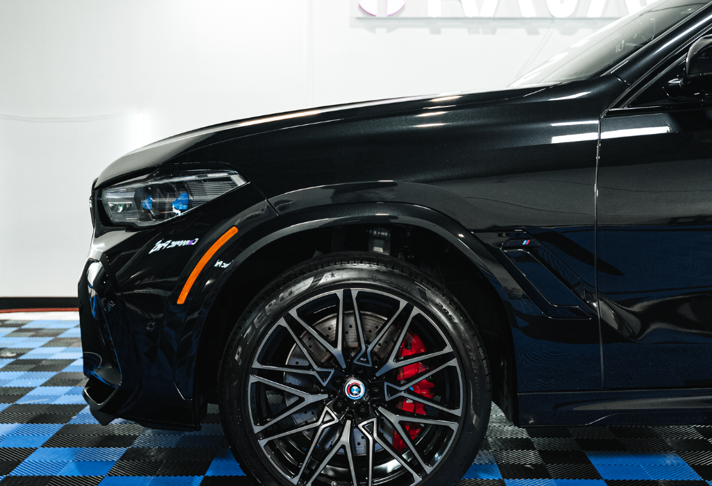 shiny black car with red brakes