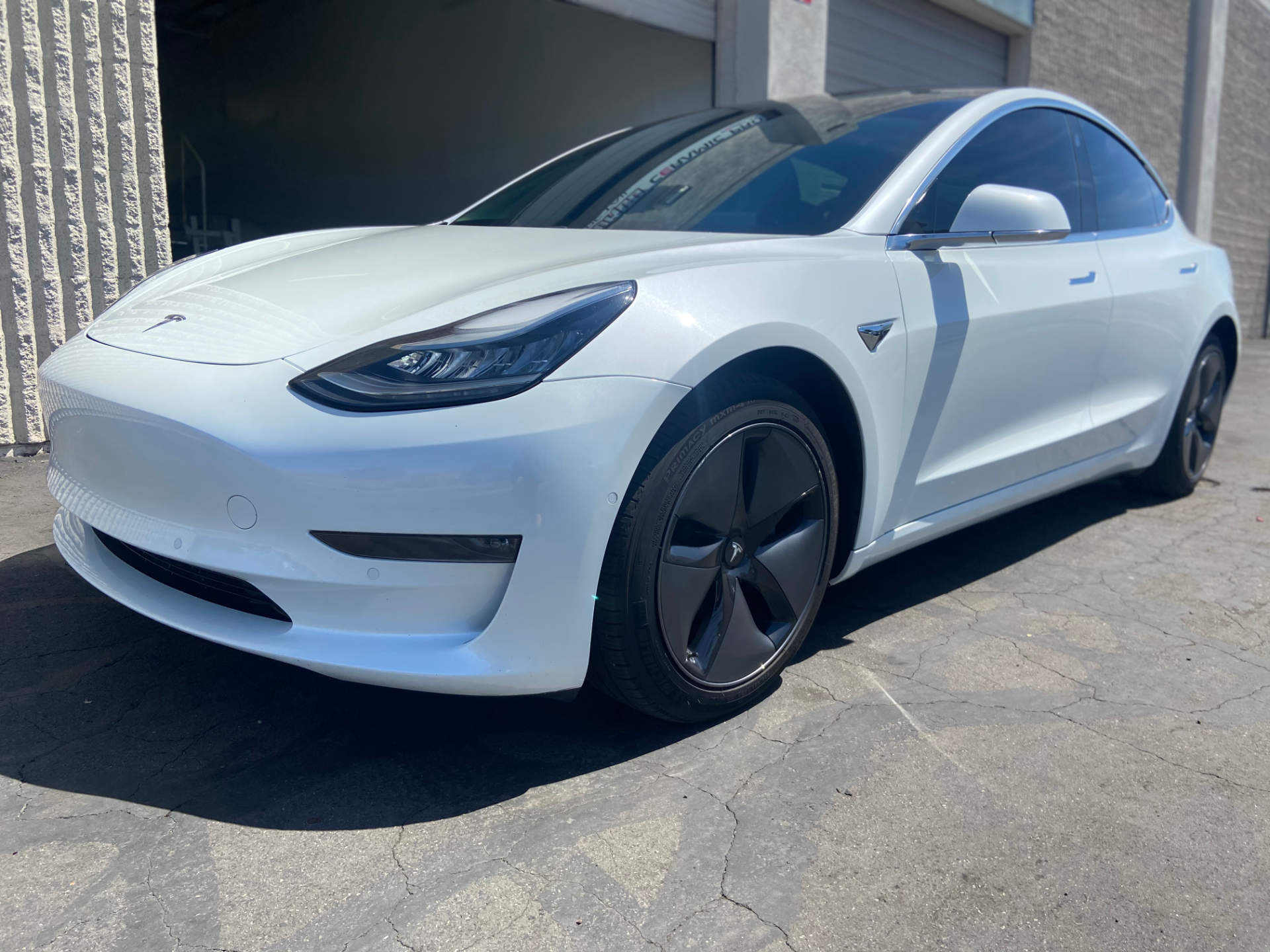 freshly detailed white tesla at the auto this world facility