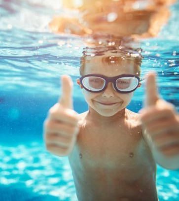 Swimming boy with thumbs up