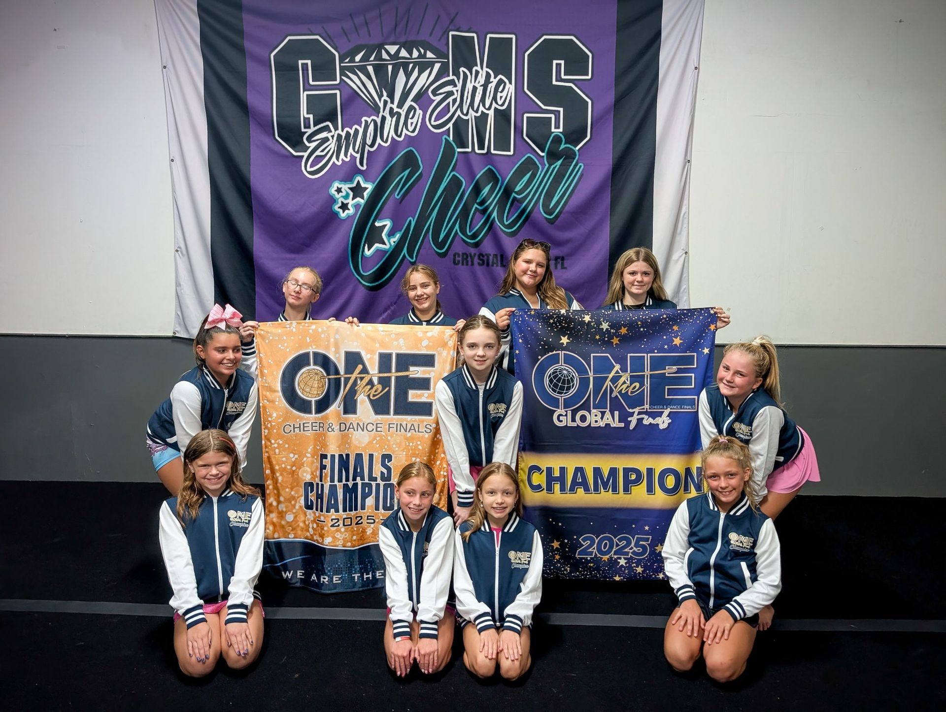 Cheerleading team celebrating their championship win with banners.