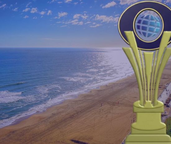 Gold trophy with globe over a beach and ocean view.