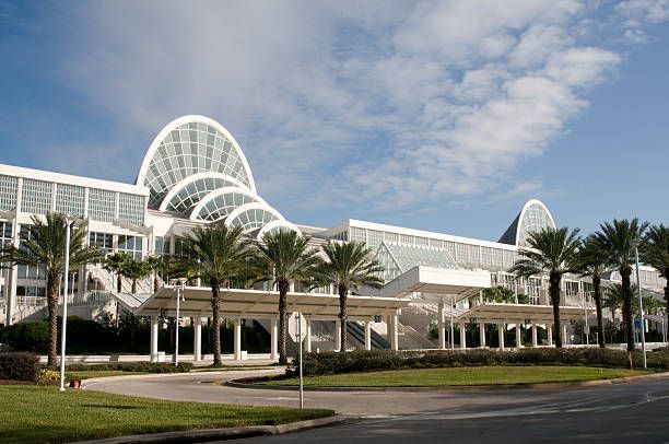 Orange County Convention Center in Orlando, Florida, with palm trees and blue sky.