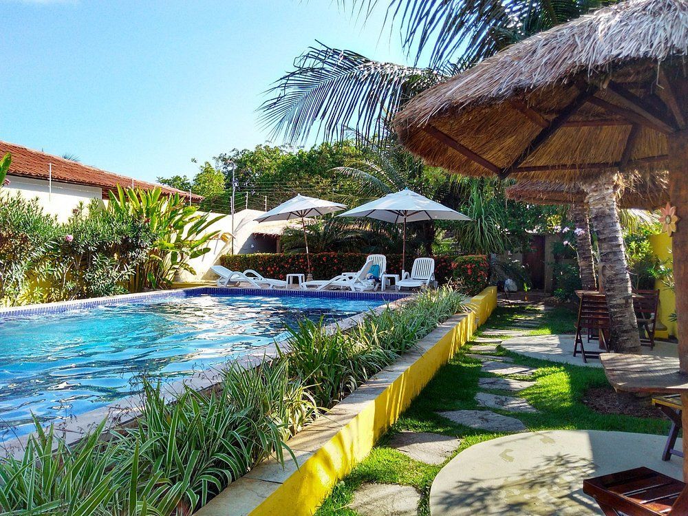 Uma piscina com cadeiras e guarda-sóis ao redor