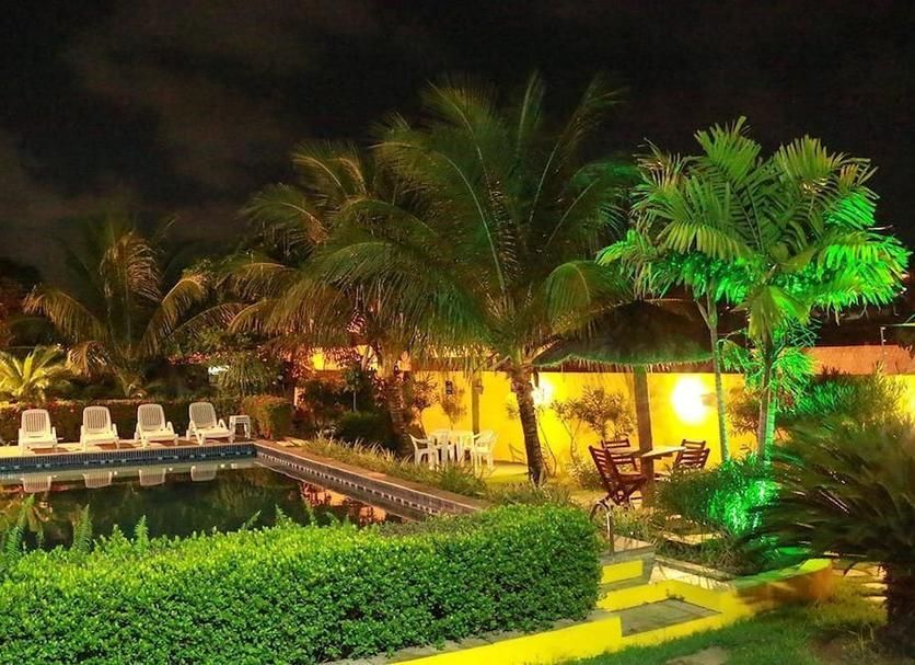 Há uma piscina no meio do jardim à noite.