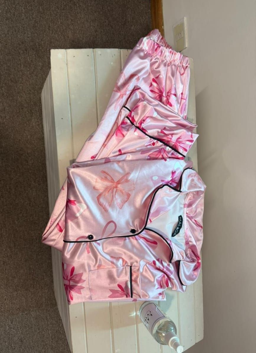Un conjunto de pijama rosa está sobre una caja blanca.