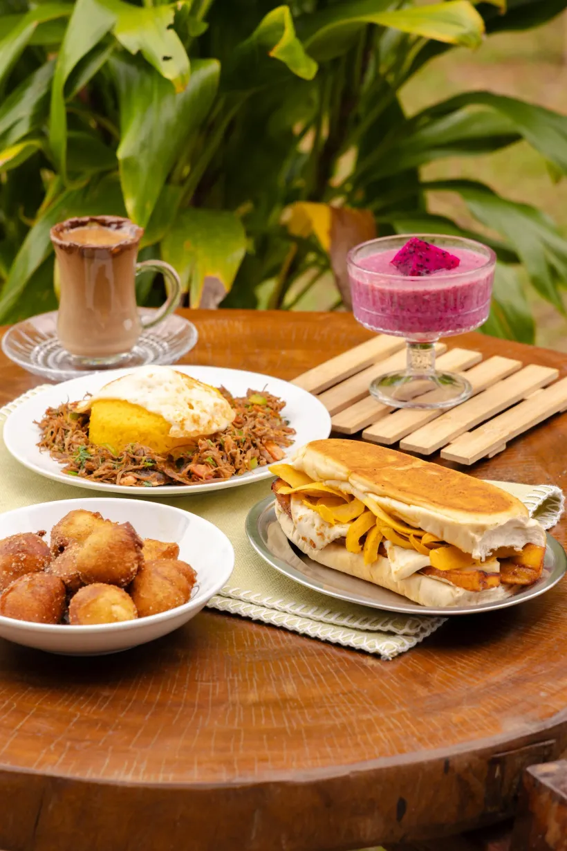 Café da manhã: arroz frito com ovo, sanduíche, doces, smoothie, café em uma mesa de madeira ao ar livre - Solar Café e Pousada