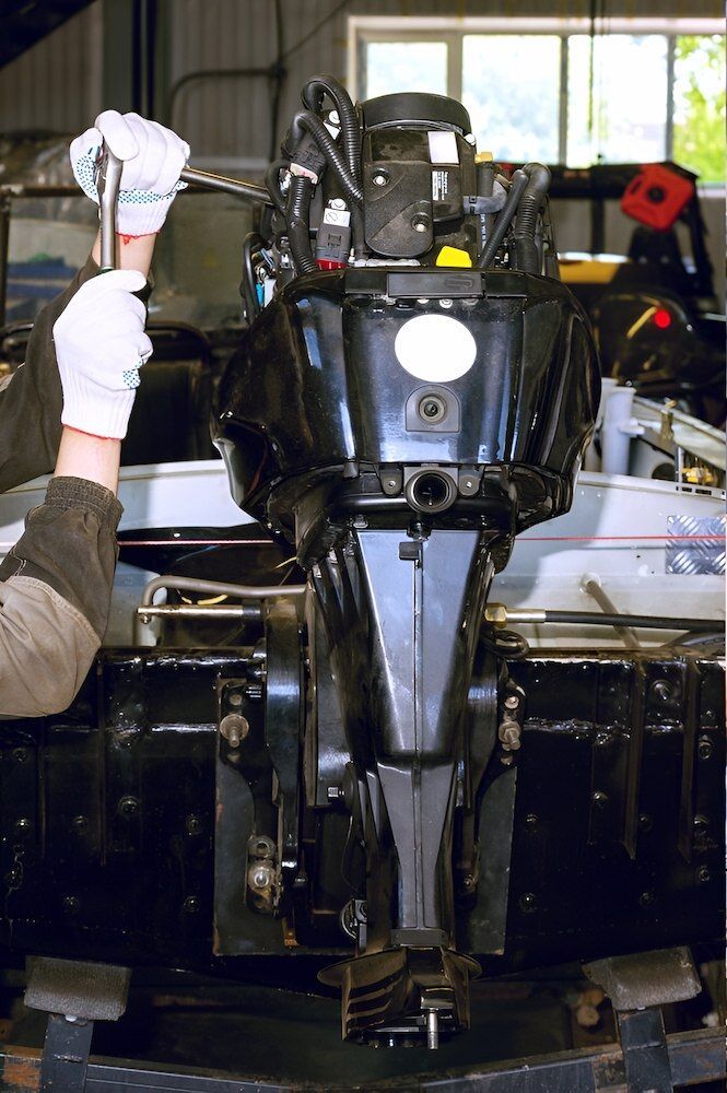 A Man is Working on a Boat Engine in a Garage — TeeJay Mechanical Repairs In Beard, ACT