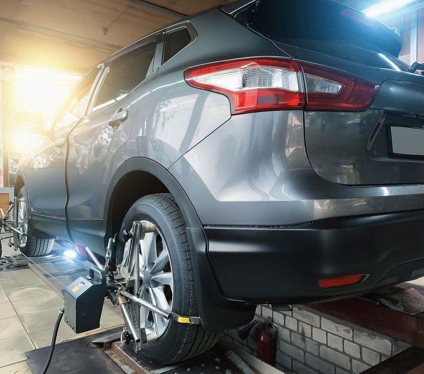 A Car is Sitting on a Lift in a Garage — TeeJay Mechanical Repairs In Beard, ACT