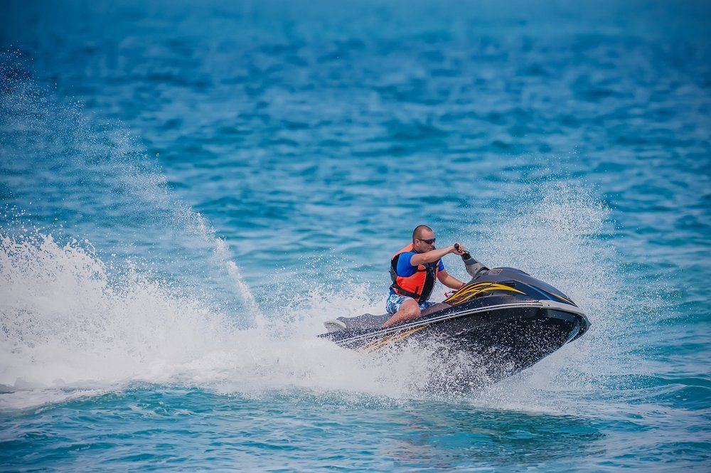 A Man is Riding a Jet Ski in the Ocean — TeeJay Mechanical Repairs In Beard, ACT