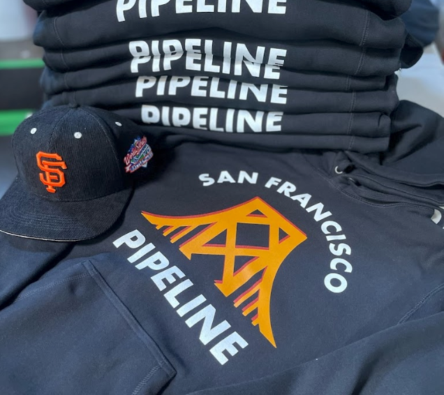 A stack of black pipeline shirts and a hat