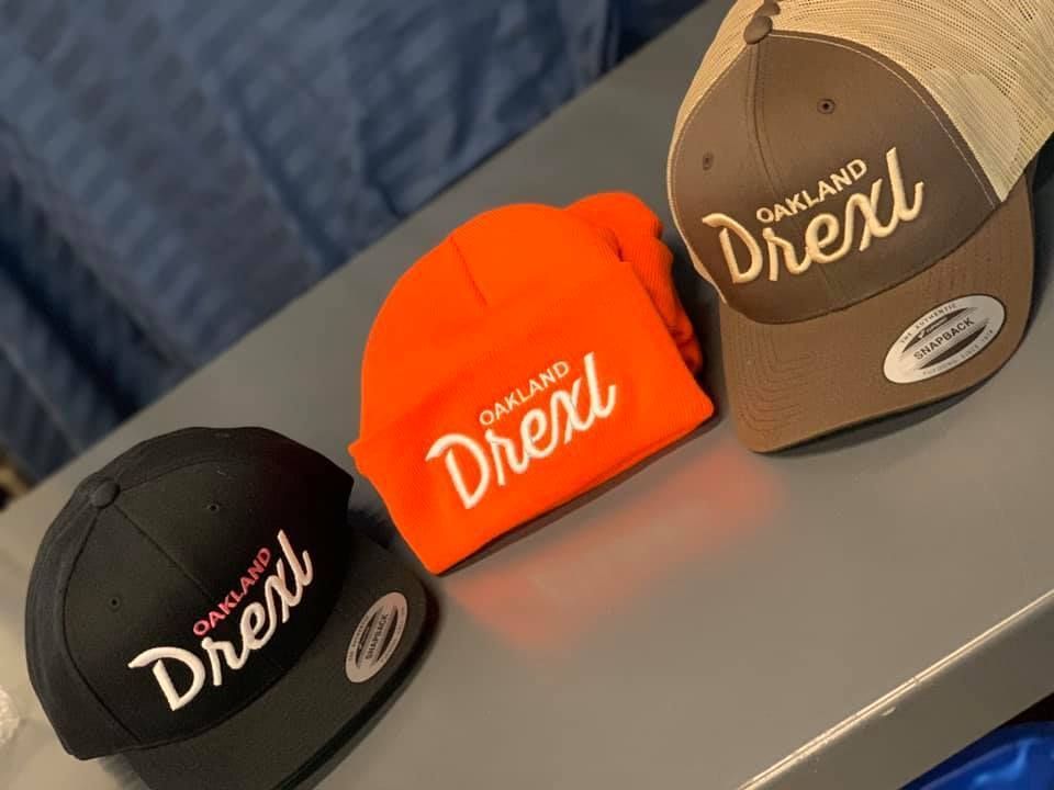 Three oakland drexel hats are sitting on a table