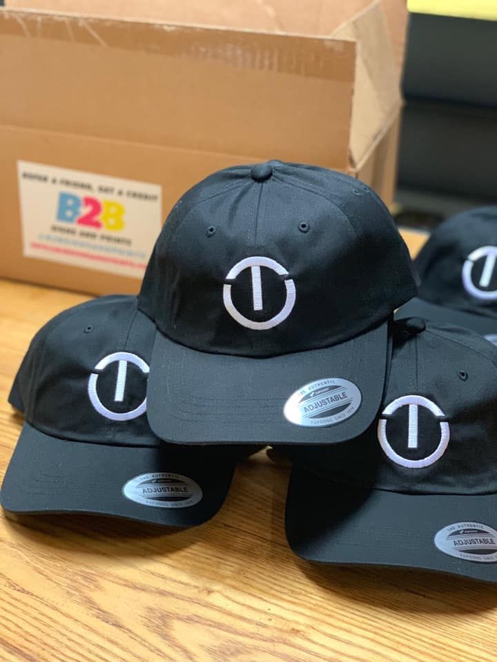 A bunch of black hats with the letter t on them