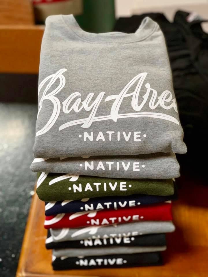 A stack of bay area native shirts on a table