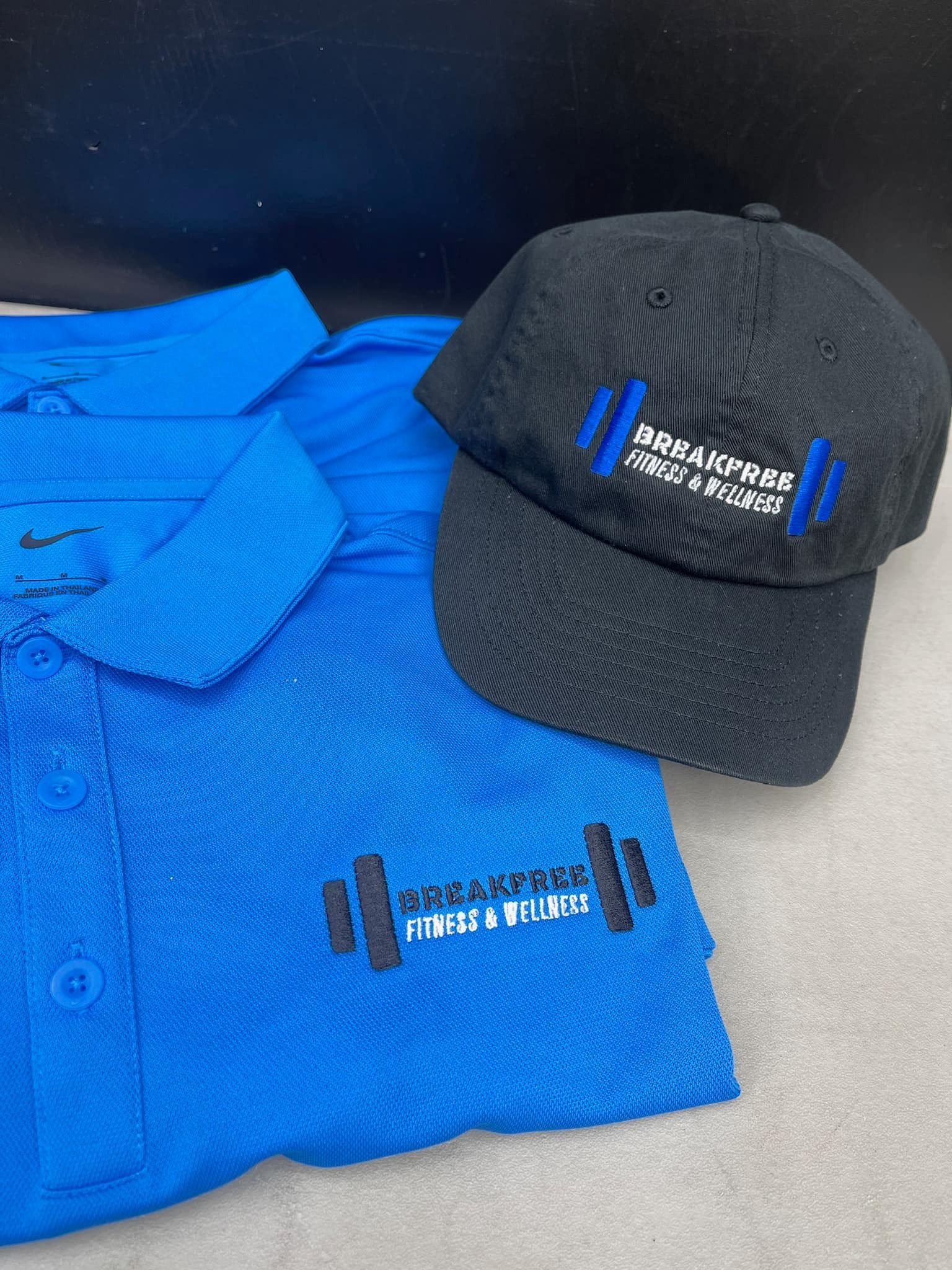 A blue shirt and a black hat are sitting next to each other on a table.