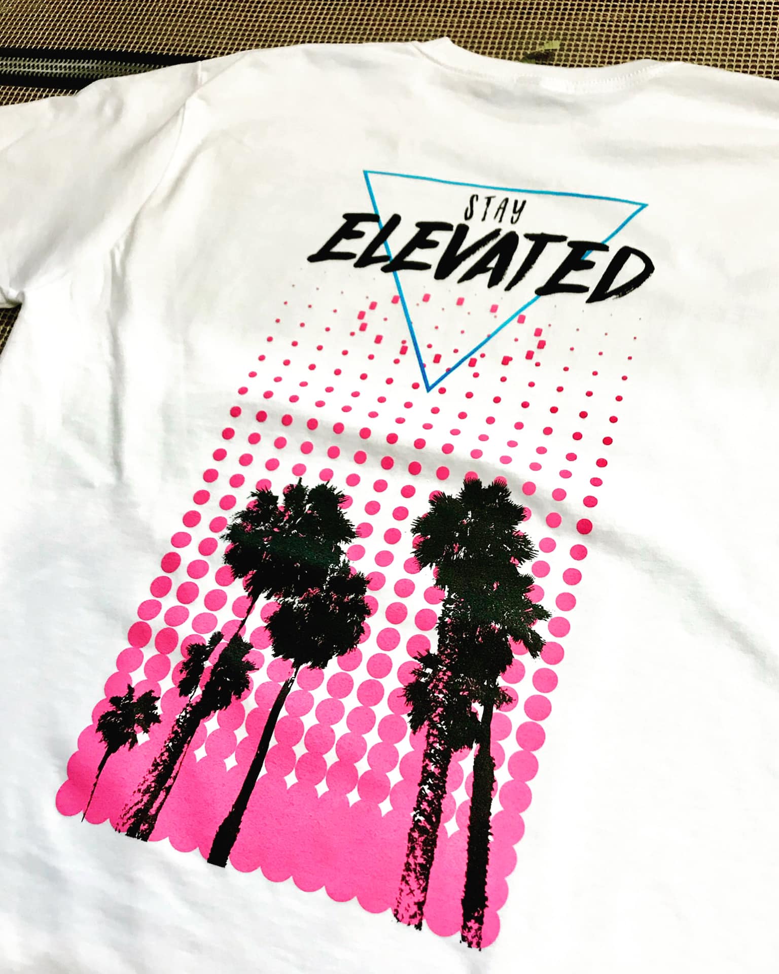 A white t-shirt with palm trees and the words