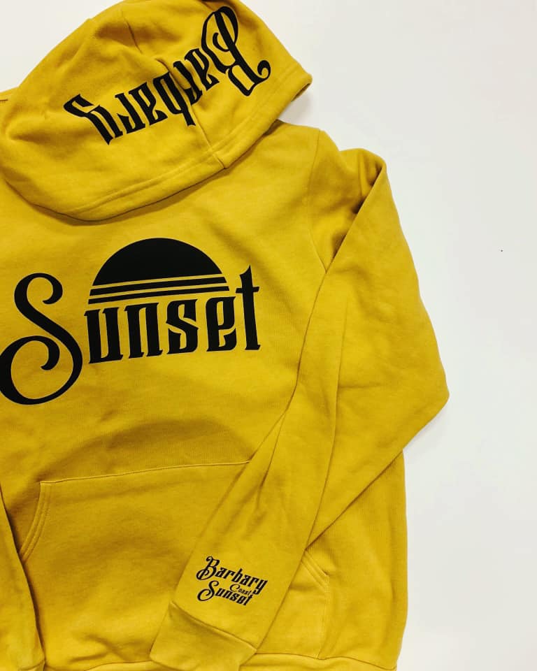 A yellow hoodie with the word sunset on the back