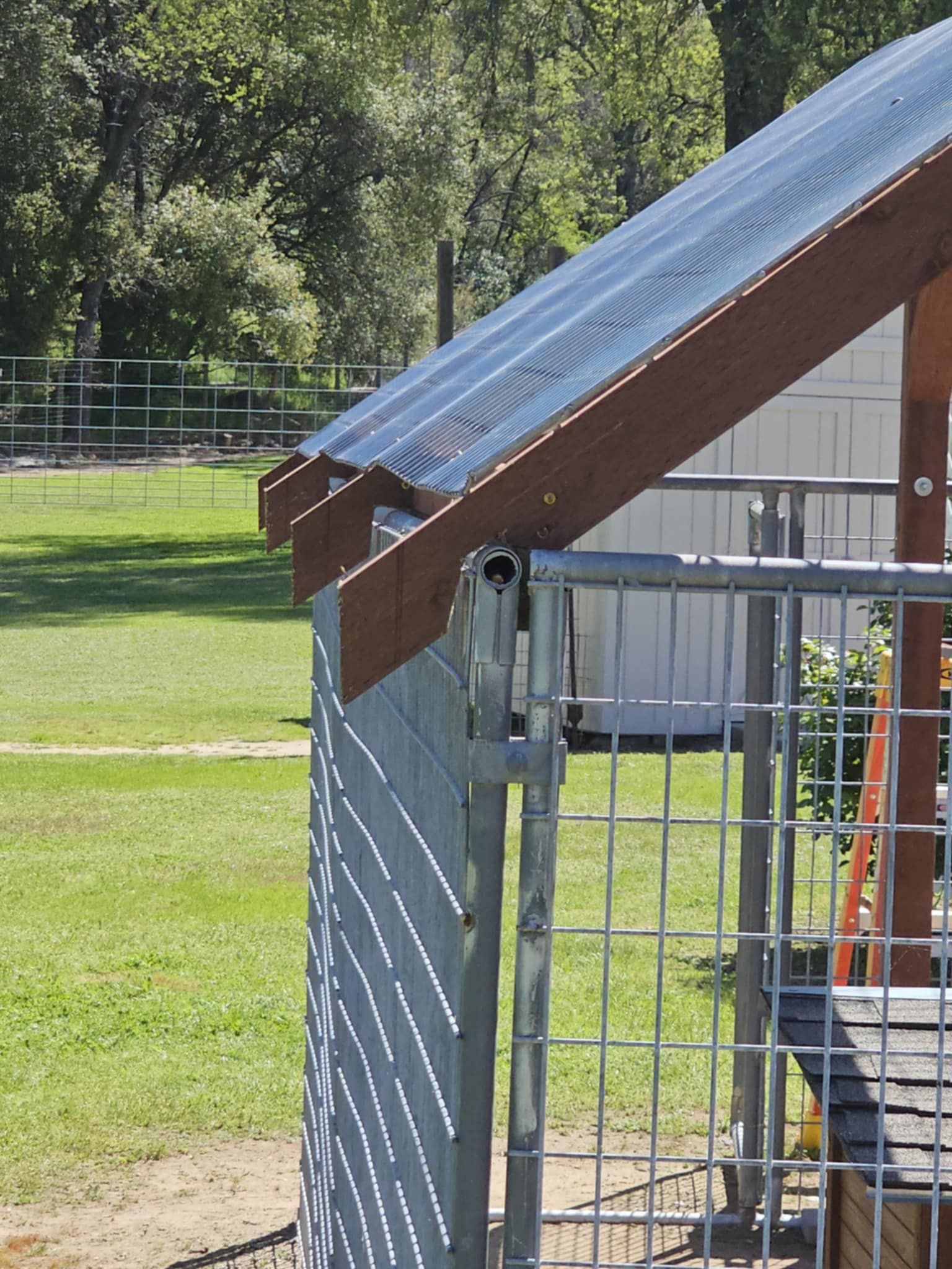 A fence with a clear roof and a wooden frame